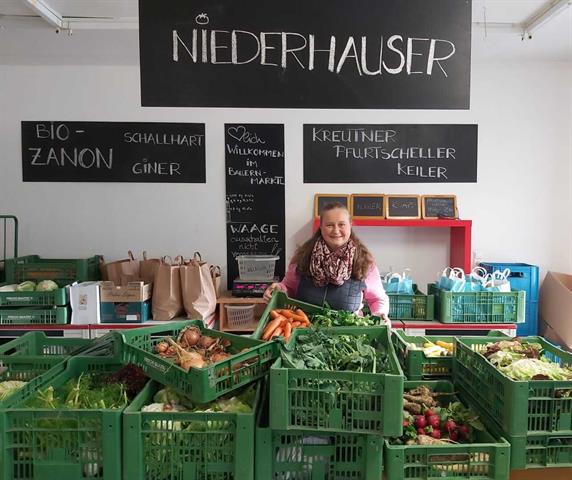 Alt-Obfrau Sabine Schwemberger im Bauernmarktl mit einer Auswahl verschiedener regionaler Produkte