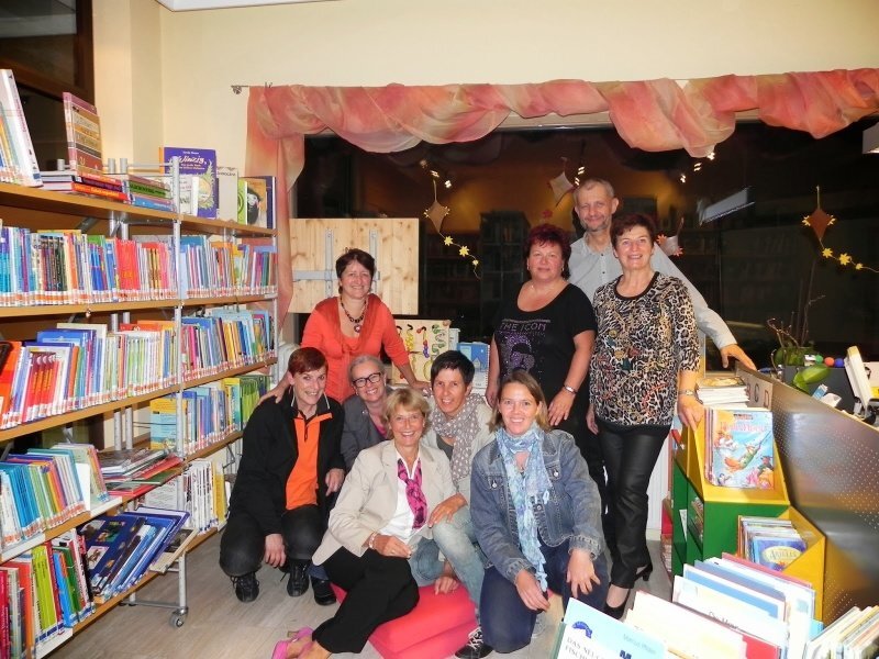 Eine Gruppe von Menschen, die in einer Bibliothek für ein Foto posieren